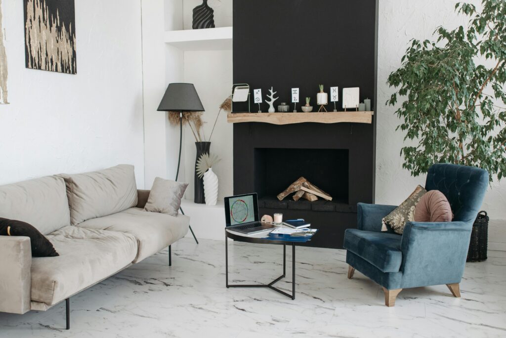 Spacious living room with a fireplace, armchair, and sofa in minimalist style.